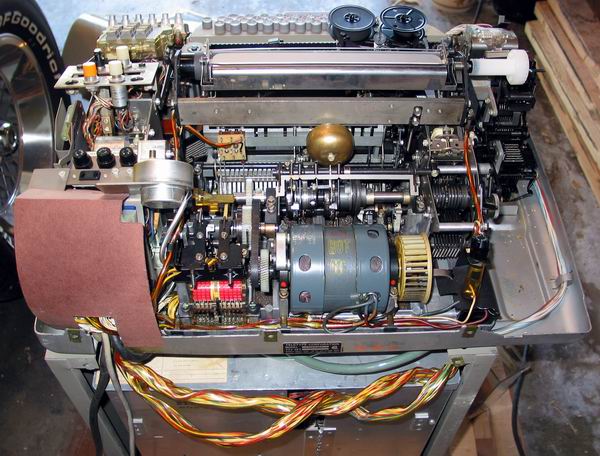 A rear view of the ASR33 Teletype with the cover off showing the motor and inner workings